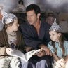 Graham (Mel Gibson, center) tries to calm his children, Morgan (Rory Culkin, left) and Bo (Abigail Breslin, right), who think that tin foil hats can stop aliens from reading their minds.